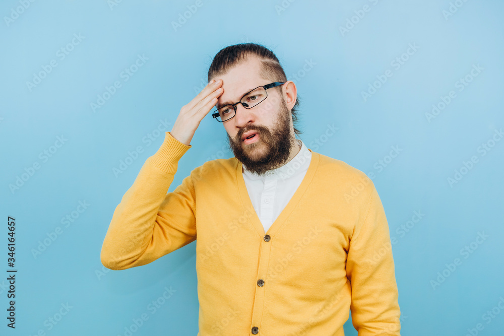 The guy with the symptoms of a grit on a blue background. A man with a cough, a headache, a fever. Symptoms of coronavirus. COVID 2019 Epidemic The guy with the symptoms of a grit on a blue background. A man with a cough, a headache, a fever. Symptoms of coronavirus. COVID 2019 Epidemic