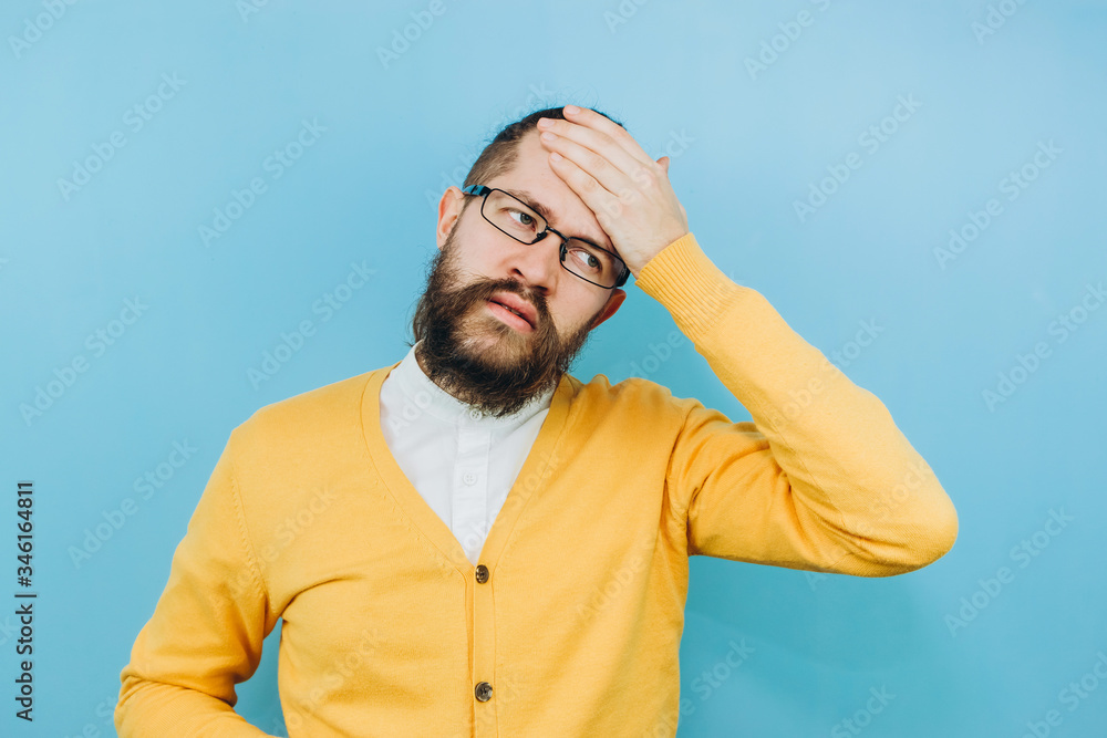 The guy with the symptoms of a grit on a blue background. A man with a cough, a headache, a fever. Symptoms of coronavirus. COVID 2019 Epidemic The guy with the symptoms of a grit on a blue background. A man with a cough, a headache, a fever. Symptoms of coronavirus. COVID 2019 Epidemic