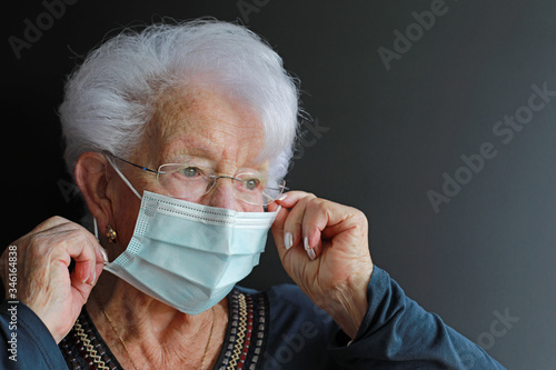 persona mayor poniendose la mascarilla médica facial antivirus mujer 4M0A0713-as20 photo