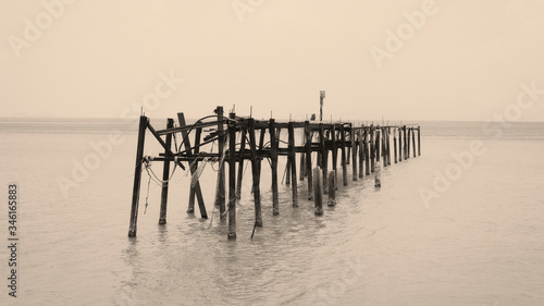 A Sepia tone photo of an old wooden jetty at Bophut beach in Koh Samui, Thailand. This is a popular tourist attraction on the island.  photo