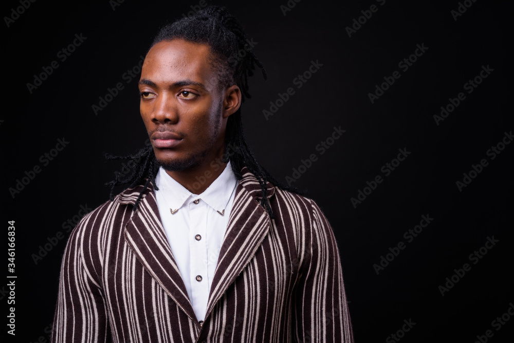 Fototapeta premium Face of young handsome African businessman in suit with dreadlocks