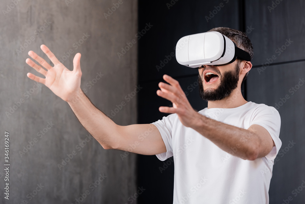 Shocked man using virtual reality headset at home