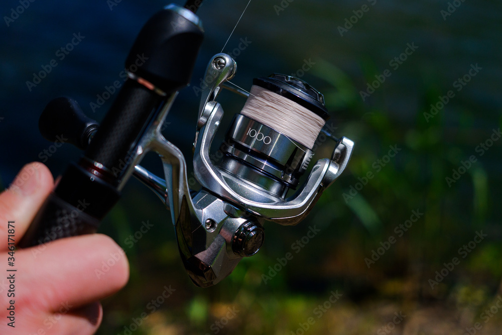 .Spinning the rod against the background of the pond professional tool for fishing a predatory fish on the line .Spinning the rod against the background of the pond professional tool for fishing a predatory fish on the line