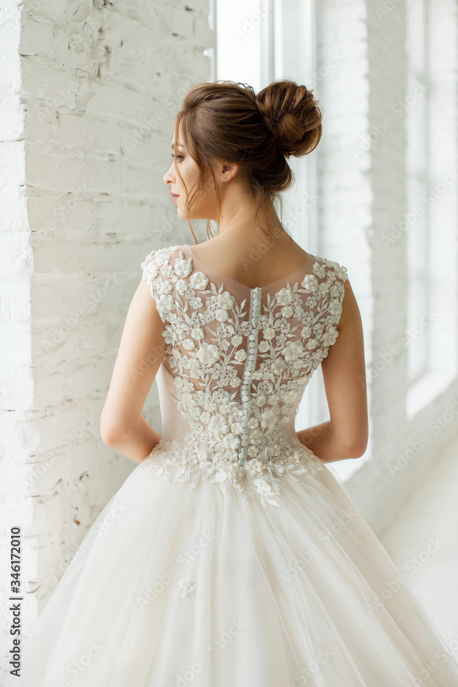 bride in white wedding dress. happy beautiful young woman in white traditional wedding dress on white background. big windows and white walls. bride in white wedding dress. happy beautiful young woman in white traditional wedding dress on white background. big windows and white walls.