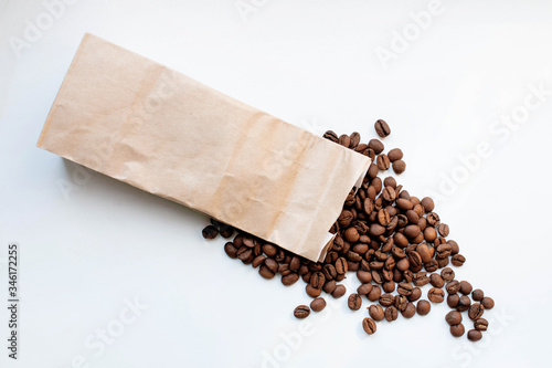 coffee in a paper bag. coffee beans in a paper bag. high-class coffee spilled out of the bag.