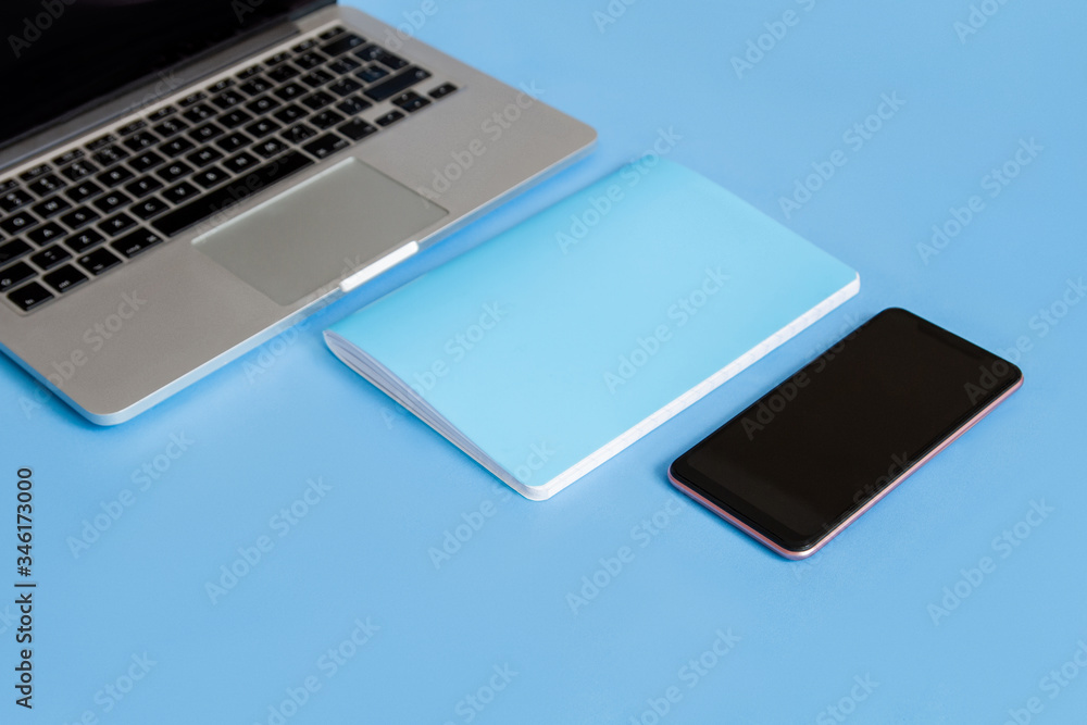 Laptop on a blue background. Laptop and bottle on a blue background. Laptop phone and notepad on a blue background. Laptop phone, notepad and bottle on a blue background. Laptop on a blue background. Laptop and bottle on a blue background. Laptop phone and notepad on a blue background. Laptop phone, notepad and bottle on a blue background.