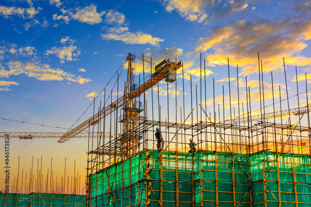 Tower crane and building construction site silhouette at sunrise. Tower crane and building construction site silhouette at sunrise.