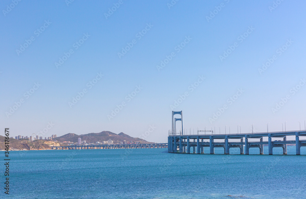 Black stone and city cross-sea bridge in the sea in Dalian, Liaoning, China in the morning
