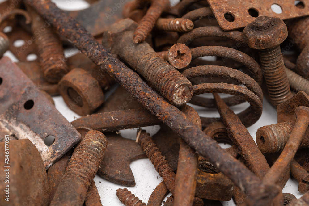 a mountain of various rusty metal construction parts on a white background. Selective focus a mountain of various rusty metal construction parts on a white background. Selective focus