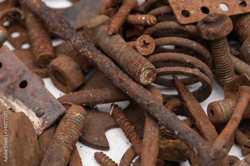 a mountain of various rusty metal construction parts on a white background. Selective focus