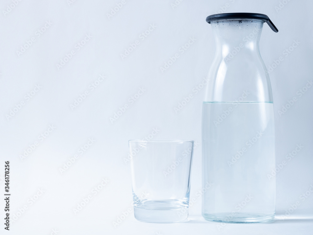 carafe with water and a glass on a light background carafe with water and a glass on a light background