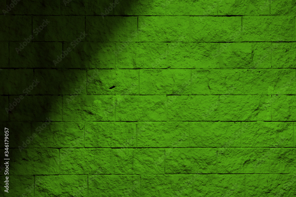 Fototapeta premium Green wall with a shadow. Green background with shadow. Green block wall.