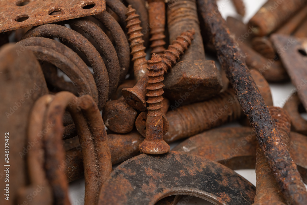 a mountain of various rusty metal construction parts on a white background. Selective focus a mountain of various rusty metal construction parts on a white background. Selective focus