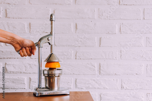 Metal manual juicer.Make juice yourself.Freshly squeezed orange juice.Natural vitamins.Fresh.Homeliness.Cooking equipment.Kitchen accessories.Healthy eating.Press for fruits.Place for text.Aesthetiс.