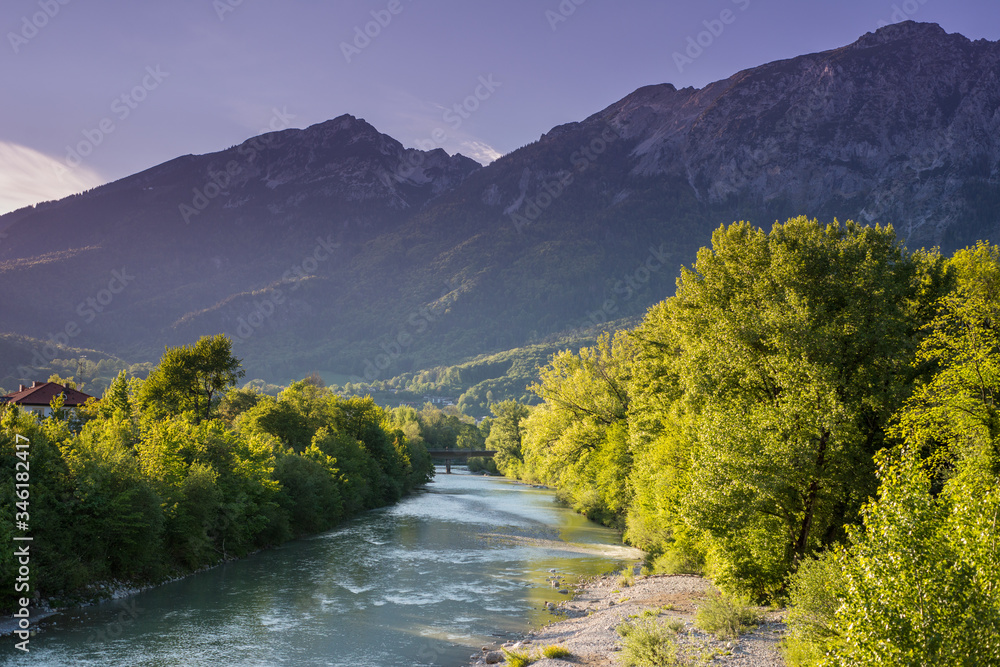 Mountain river in the town of Bad Reichenhall in the Bavarian Alps, with distant high mountains in the spring.