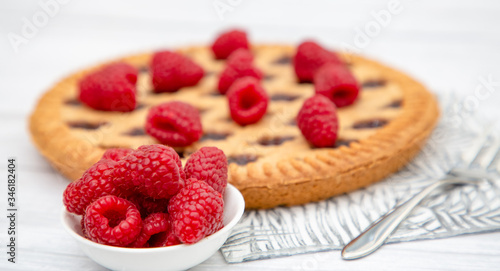 Dessert Raspberry Pie cake with strawberry or Fruit in a round bread for Break time or a party shot at the top view and copy space on a white wooden table.