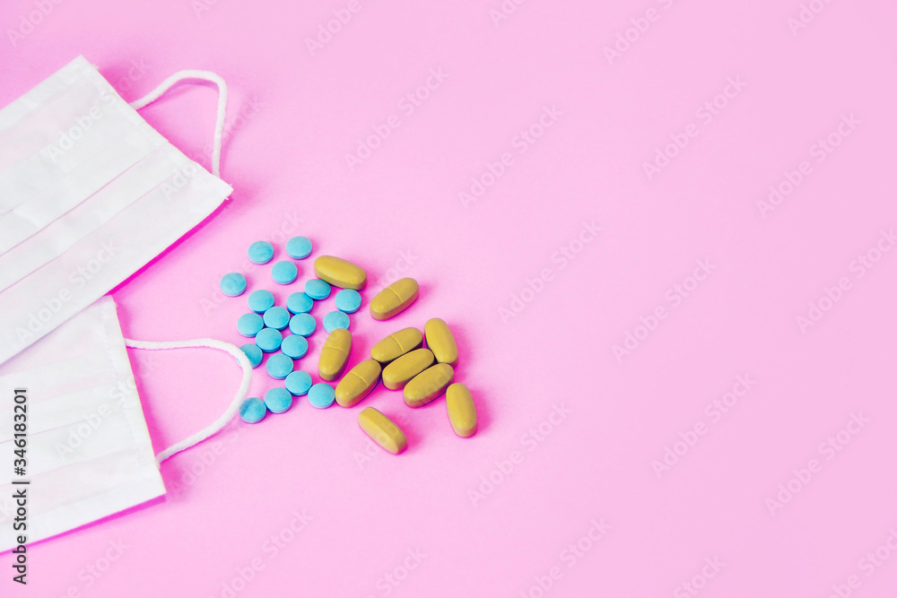 white medical masks and tablets on a pink background white medical masks and tablets on a pink background