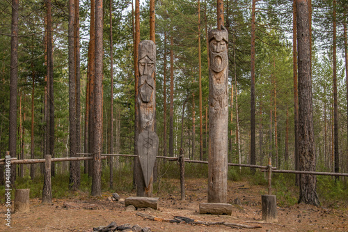 Siberia. A pagan temple in the taiga, with two wooden idols. The image of the pagan Gods is carved on wooden poles.