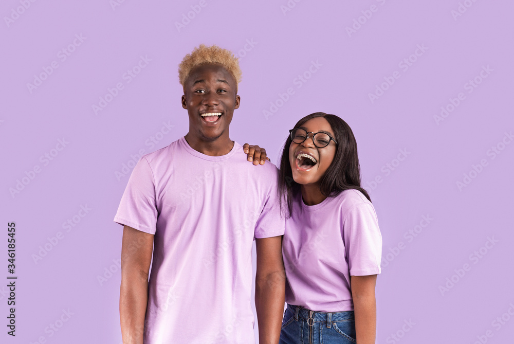 Young African American couple smiling on lilac background Young African American couple smiling on lilac background