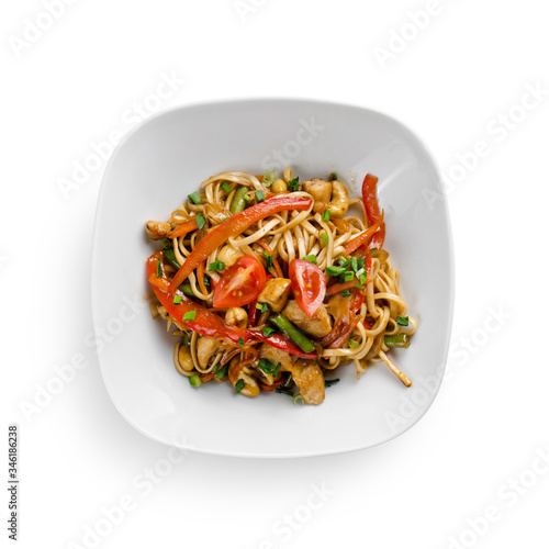 Fried udon noodles in a wok with chicken fillet and green beans. Traditional asian food. Isolated on white background.