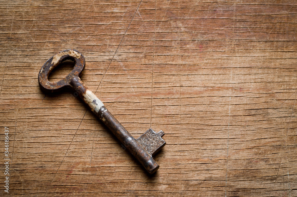 Iron old key, photographed on a shabby wooden surface. Iron old key, photographed on a shabby wooden surface.