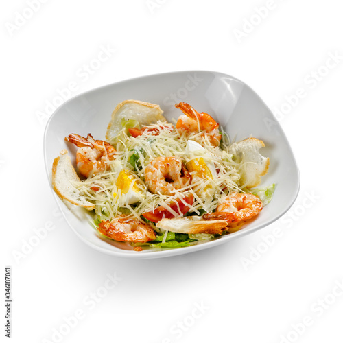 Caesar Salad with grilled shrimps. Isolated on a white background.