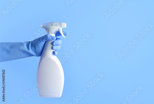 Fotografie Hand with rubber gloves holding spray bottle