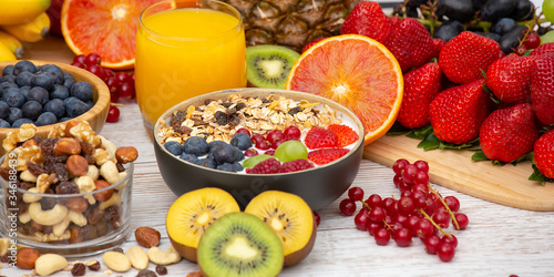 Fototapeta Naklejka Na Ścianę i Meble -  Group Fruits Breakfast mixed vegetables with salad bowl, nuts bowl, strawberry, banana, and pineapple, orange juice,  vitamin c in food  nature for health and diet in the top view on the wood table.