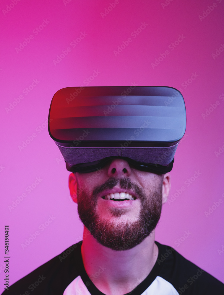 vertical portrait of man using VR glasses on colorful gradient background vertical portrait of man using VR glasses on colorful gradient background