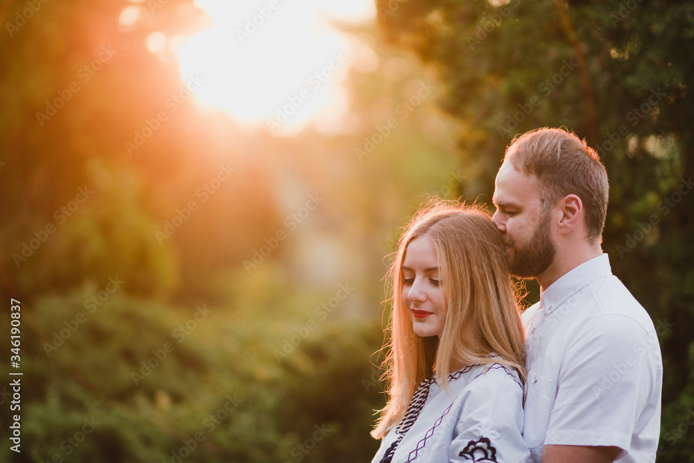 Romantic and happy caucasian couple in casual clothes hugging on the background of beautiful nature. Love, relationships, romance, happiness concept. Man and woman walking outdoors together. Romantic and happy caucasian couple in casual clothes hugging on the background of beautiful nature. Love, relationships, romance, happiness concept. Man and woman walking outdoors together.