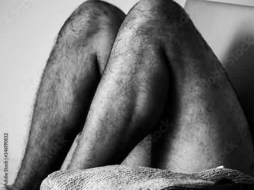 Home working.
Black and white picture who depict a man with hairy legs who is chilling or home working on his bed with his computer on his legs.