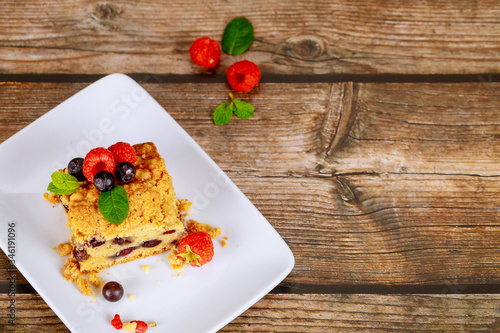 Portion of blueberry coffee cake on wooden background.