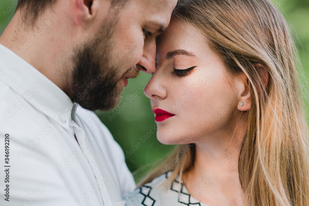Romantic and happy caucasian couple in casual clothes hugging on the background of beautiful nature. Love, relationships, romance, happiness concept. Man and woman walking outdoors together. Romantic and happy caucasian couple in casual clothes hugging on the background of beautiful nature. Love, relationships, romance, happiness concept. Man and woman walking outdoors together.