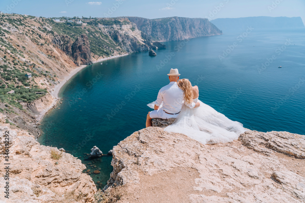 The bride in a wedding dress, the groom in a white shirt, shorts, hat. The concept of romance, travel, adventure