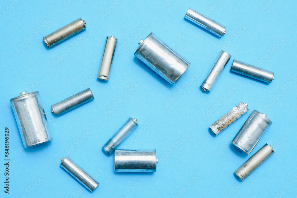 Close up of spent used rechargeable Nickel Metal Hydride (Ni-MH) battery on grey background, flat lay. Old Nickel-Cadmium (Ni-Cd) batteries without a protective shell with corrosion and rust Close up of spent used rechargeable Nickel Metal Hydride (Ni-MH) battery on grey background, flat lay. Old Nickel-Cadmium (Ni-Cd) batteries without a protective shell with corrosion and rust