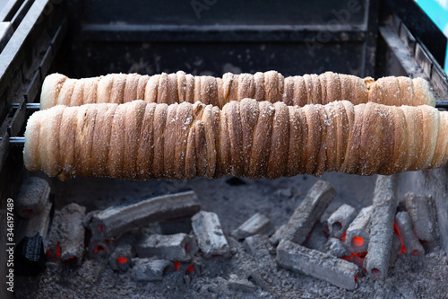 On a spit, the pastry tubes are sprinkled with sugar.Traditional Czech dessert.
