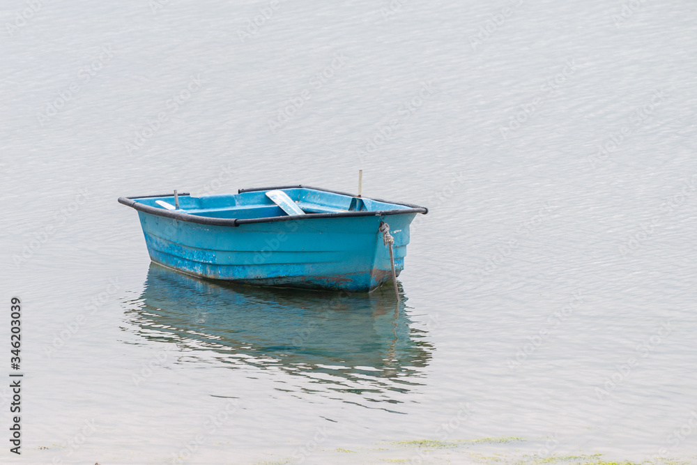 Naklejka premium wooden fishing boat anchored near the coast.