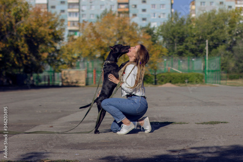 Dreadlocks girl with her handsome black dog pitbull