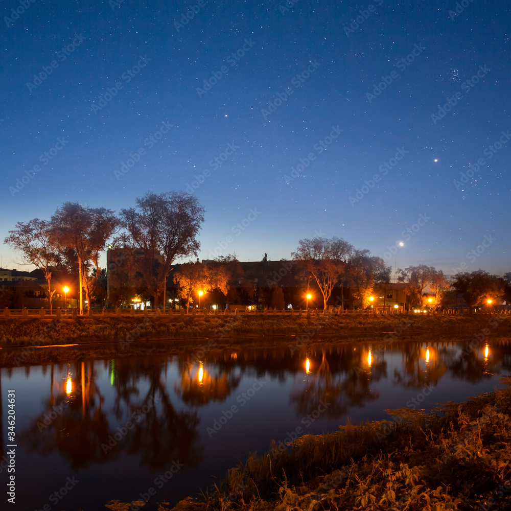 night city embankment with lanterns under a starry sky