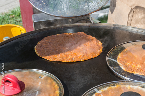Traditional Turkish pizza, called Lahmacun, being prepared with meat, onion and parsley
