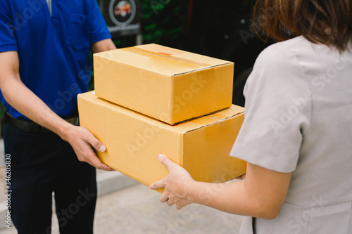 delivery man in blue uniform sending a delivery of boxes to recipient