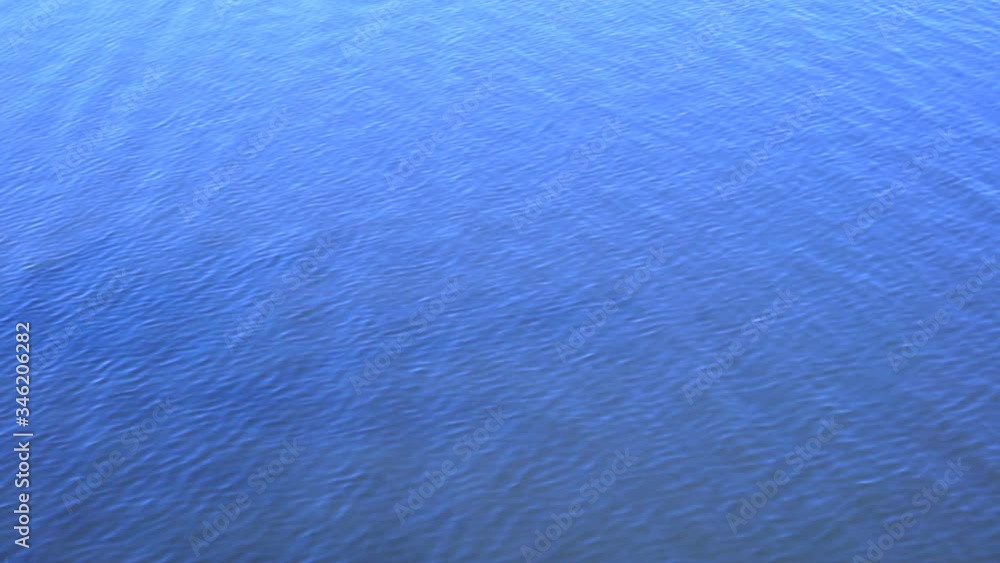 Ripples on the water background. Shallow waves and ripples on the surface of blue water in a river or lake. Ripples on the water background. Shallow waves and ripples on the surface of blue water in a river or lake.