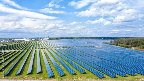Aerial view to solar power plant. Industrial background on renewable resources theme.