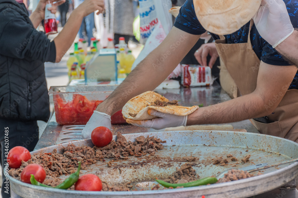 Traditional Turkish shawarma meat being prepared with red tomatoes