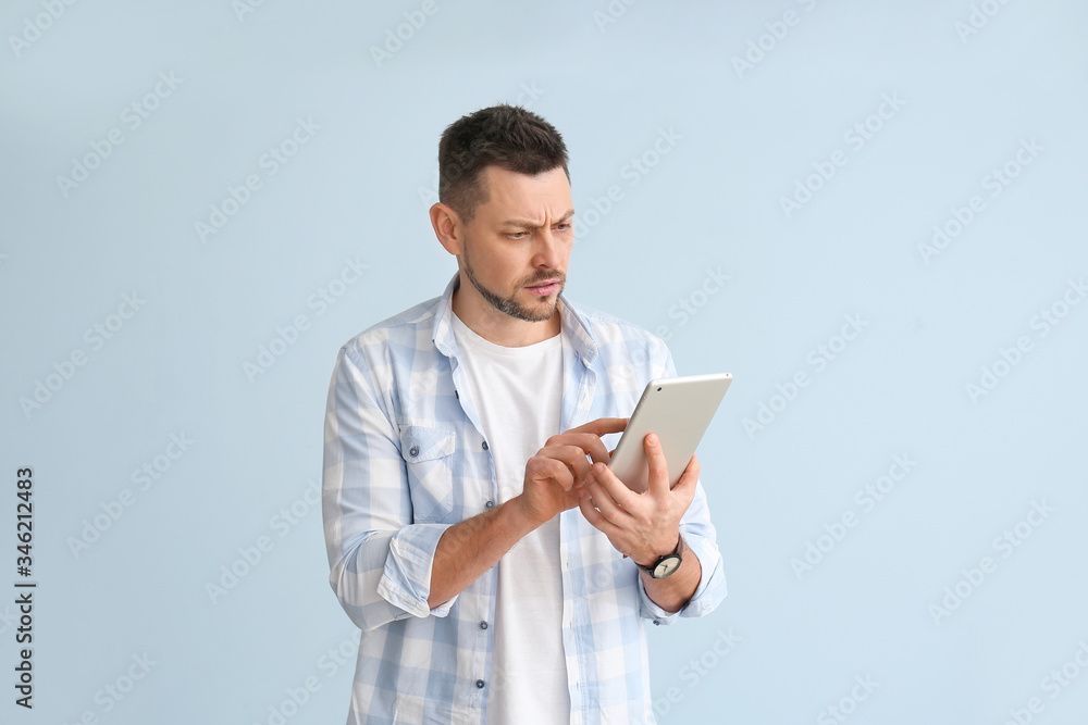 Handsome man with tablet computer on color background Handsome man with tablet computer on color background