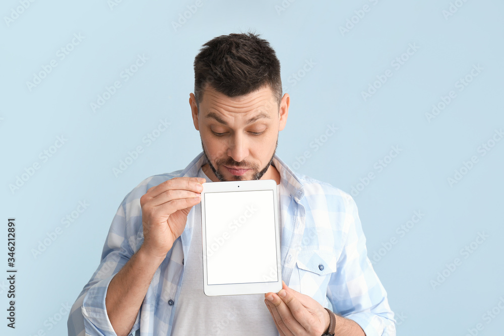 Handsome man with tablet computer on color background Handsome man with tablet computer on color background