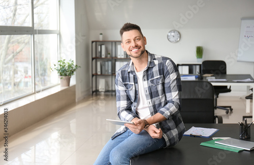 Handsome man with tablet computer in office