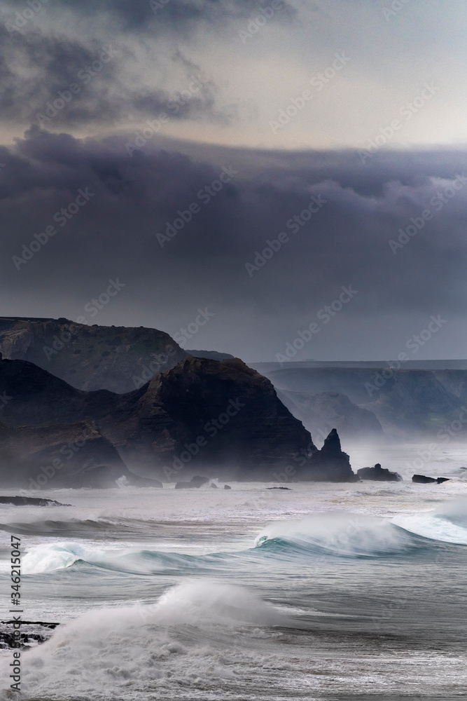 Scenic view of the coastline along the Amado Beach (Praia do Amado) with big waves during a storm, in Algarve, Portugal