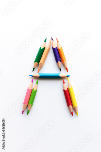 Letter A composed of colored pencils on white paper