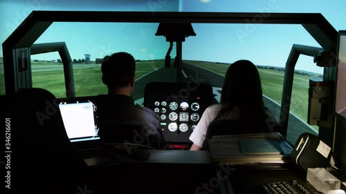 MS Rear view of student pilots in helicopter flight simulator during take off